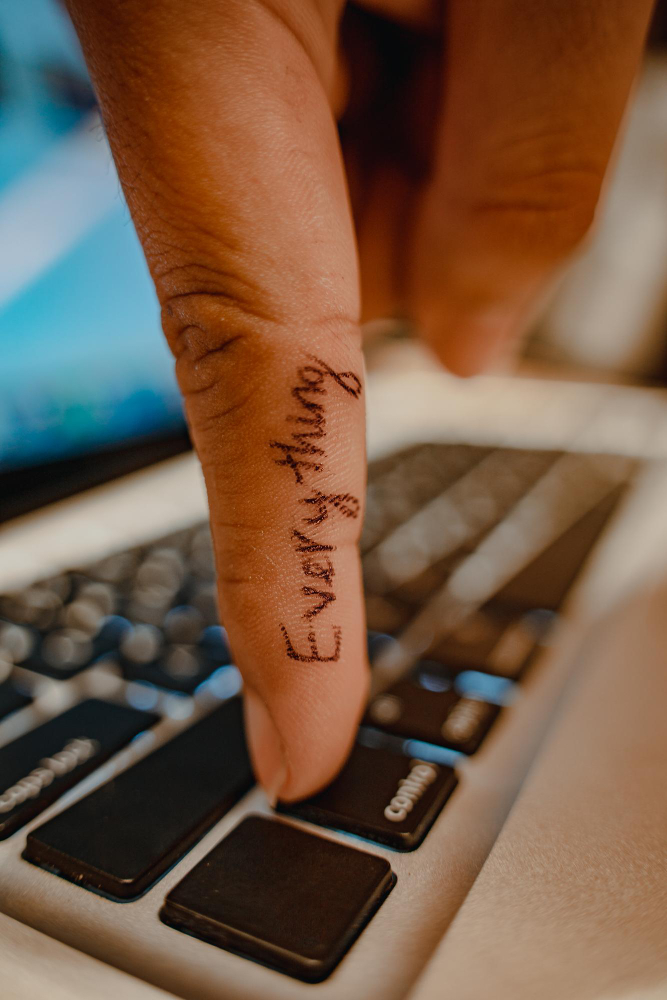 dedo con tatuaje que dice everything hace click sobre teclado de portatil